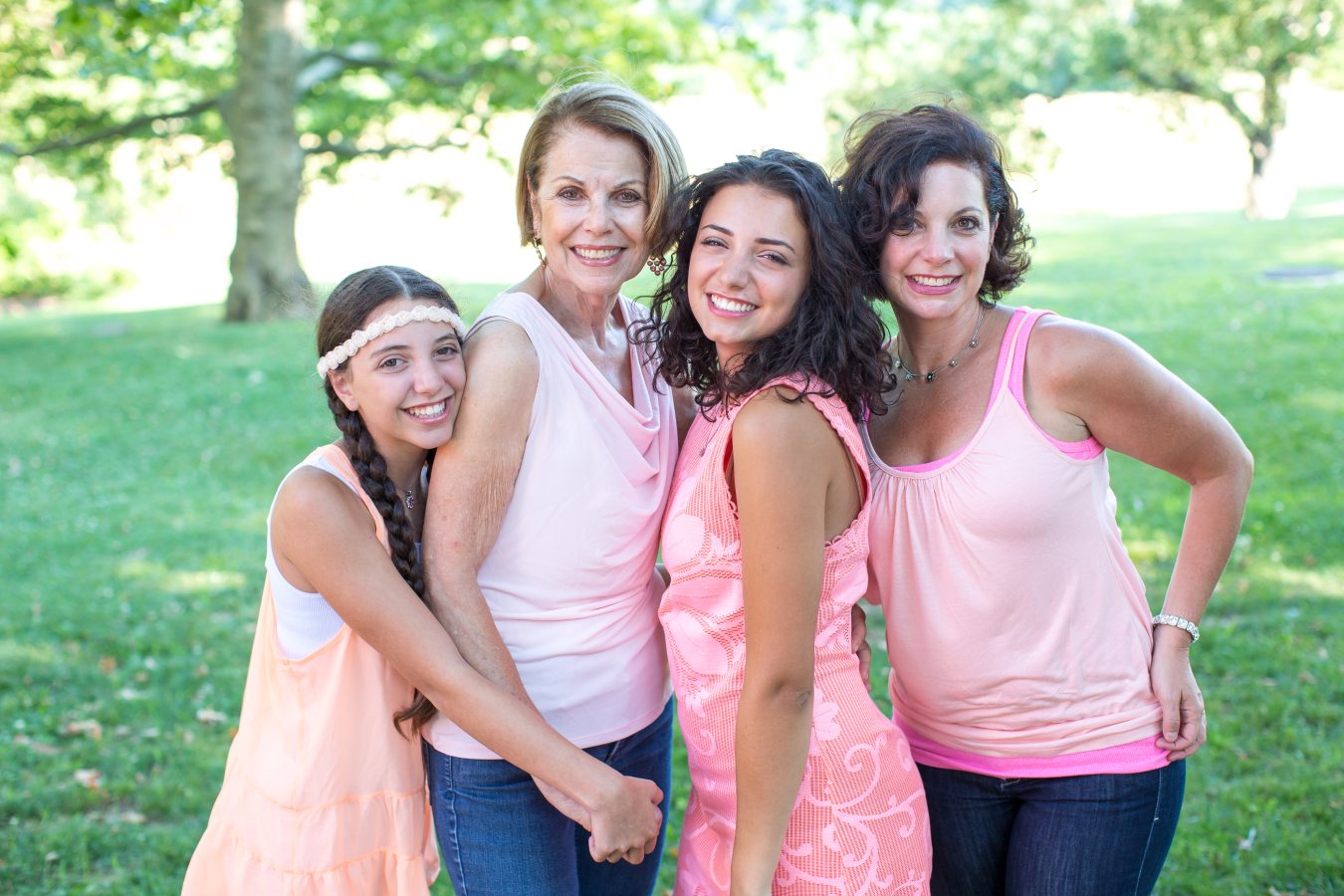 Four girls and women smiling closely together, showcasing joy and camaraderie.